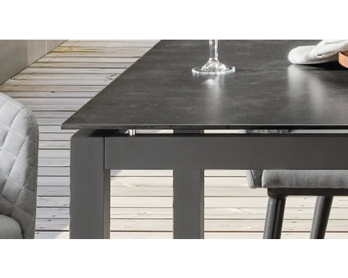 Detailansicht eines Esstisches mit dunkler Tischplatte und Stuhl