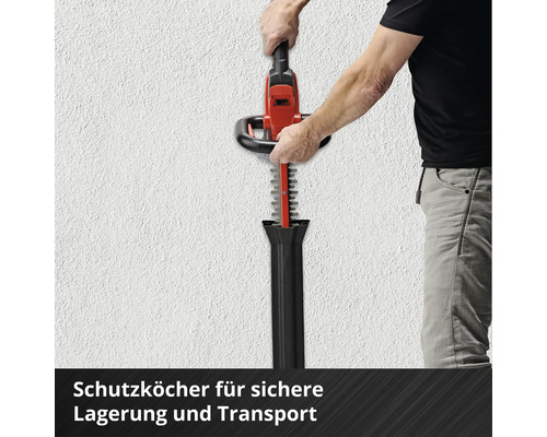 Person setzt eine Heckenschere in eine Schutzhülle zur Aufbewahrung und zum Transport