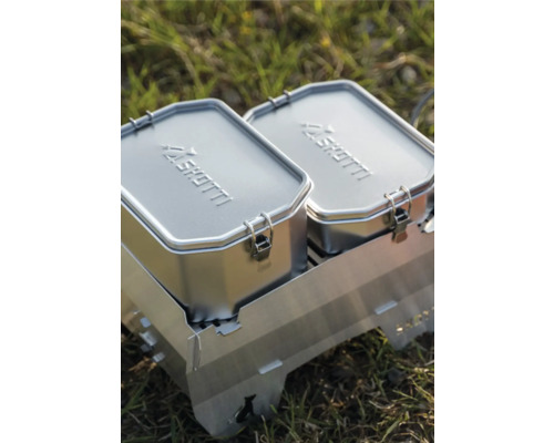 Zwei silberne SHOTTI Lunchboxen auf einem Grill