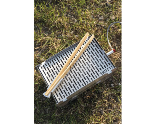 Edelstahlgrill mit Grillzange auf Gras