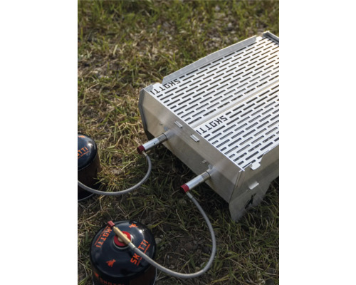 Skotti Gasgrill mit zwei Gaskartuschen auf Gras