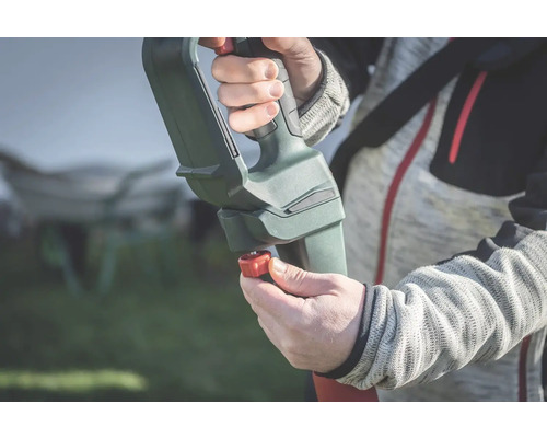 Nahaufnahme einer Person, die ein Gartengerät mit verstellbarem Griff bedient