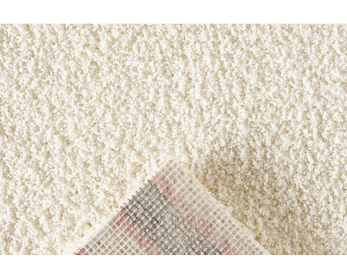 Detailansicht eines beigen Teppichs mit hochflorigem Flor