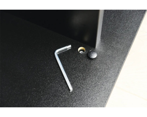 Inbusschlüssel und Abdeckkappe auf einer Möbeloberfläche