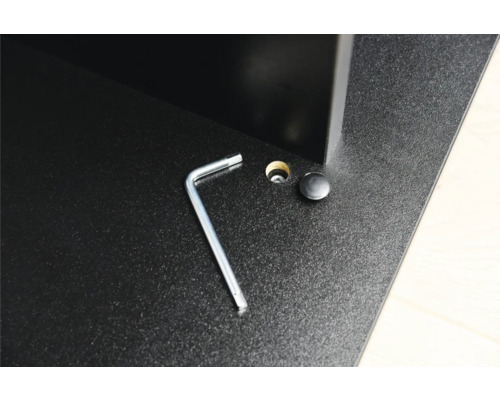 Detailaufnahme eines Möbelstücks mit Inbusschlüssel, Loch und Abdeckkappe