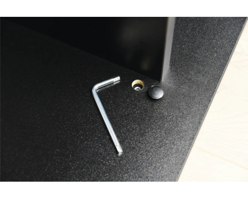 Detailansicht einer Möbelmontage mit Inbusschlüssel, Bohrloch und Abdeckkappe