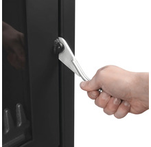 Detailansicht einer Hand, die den Griff eines Kaminofens bedient.
