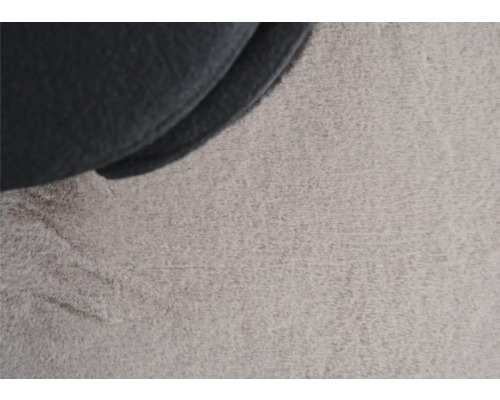 Detailaufnahme eines grauen Teppichs mit Stoffelement