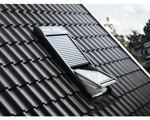 Dachfenster mit geöffnetem Rollladen in einem Ziegeldach