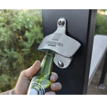 Aufnahme eines Flaschenöffners an einem Zaunpfosten, der zum Öffnen einer Glasflasche verwendet wird.