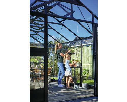 Gewächshaus mit Mutter und Tochter beim Pflanzen von Setzlingen