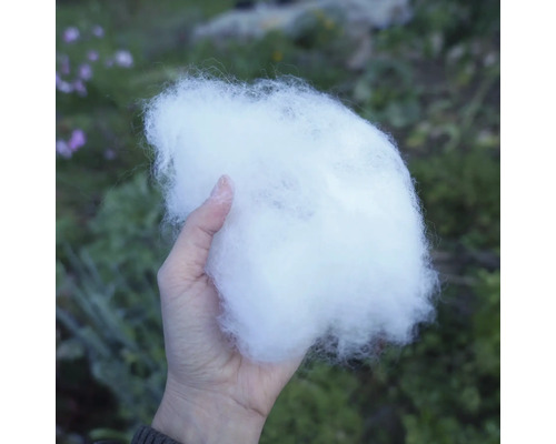 Eine Hand hält Füllwatte.