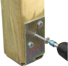 Holzpfosten mit Metallplatte und Schraube befestigt mit einem Schraubendreher