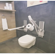 Badezimmer mit wandhängendem WC und klappbaren Haltegriffen für mehr Komfort und Sicherheit.