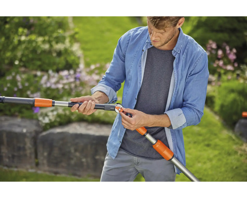 Mann justiert eine Gardena Teleskopstielverlängerung für Gartengeräte im Garten.