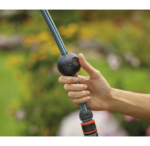 Hand hält einen flexiblen Gartenschlauch mit Kugelgelenk