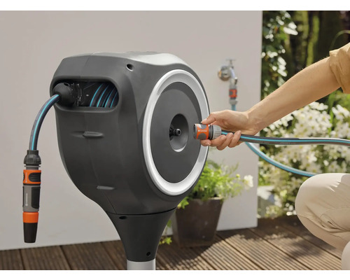 Gardena Schlauchbox mit Gartenschlauch und Anschluss an einen Wasserhahn im Außenbereich