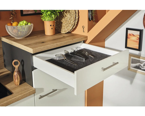 Küchenszene mit offenem Schubladenelement und Küchenutensilien