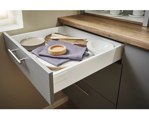 Ausgezogene Küchenschublade mit Geschirr und Küchenutensilien