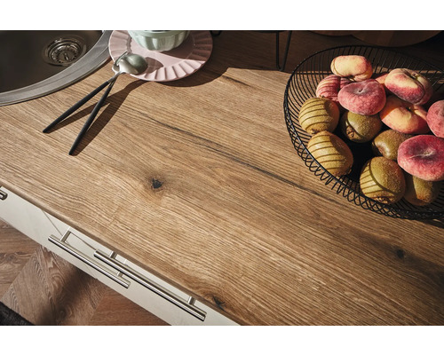 Küchenarbeitsplatte mit Spüle, Obstschale, Tellern und Besteck.