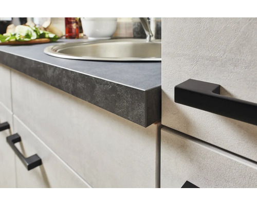 Detailaufnahme einer Küchenarbeitsplatte und Spüle mit schwarzen Griffen