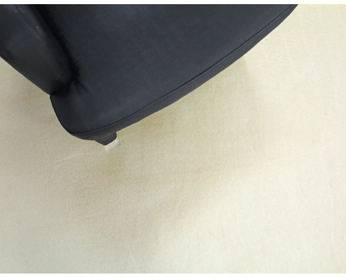 Detailaufnahme von einem schwarzen Stuhlbein auf dem Boden.