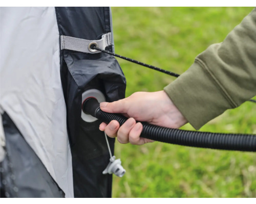 Eine Person pumpt Luft in ein aufblasbares Zelt.