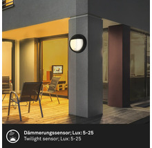 Außenbereich mit einer runden Wandleuchte an einem Pfeiler