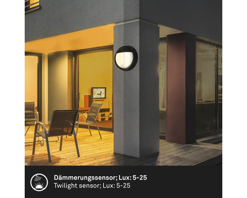 Außenbereich mit einer runden Wandleuchte an einem Pfeiler