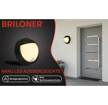 Briloner Akku LED Aussenleuchte mit Bewegungssensor und Spritzwasserschutz IP44 an einer Hauswand montiert.