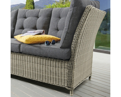 Gartensofa aus Rattan mit grauen Polstern, gelbem Kissen und Sonnenbrille