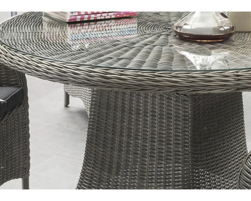 Detailansicht eines runden Gartentisches mit Glasplatte und Rattangeflecht