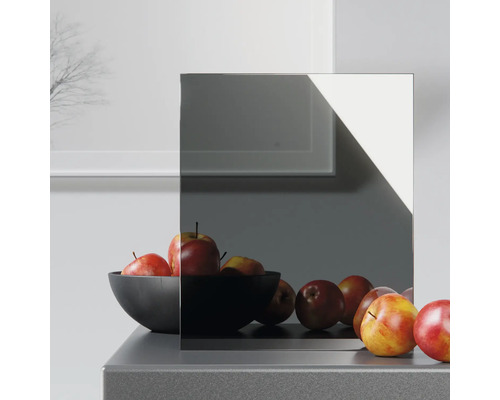 Graues Spiegelglas auf einer Kommode mit einer Schale Äpfel