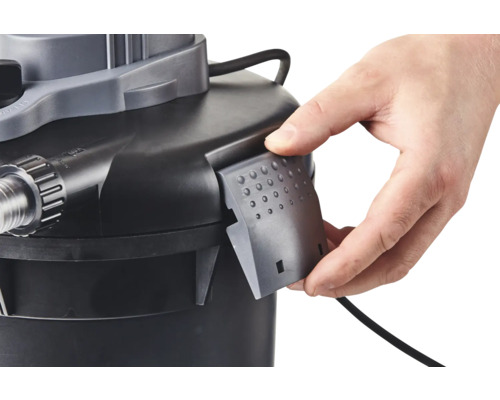 Detailaufnahme eines Teichfilters mit einer Hand, die eine Abdeckung anbringt