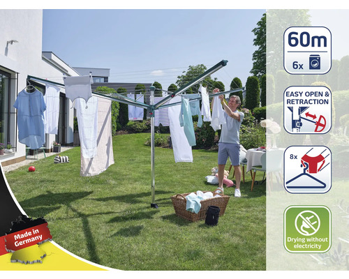Drehwascheständer im Garten mit Wäsche und Mann beim Aufhängen der Wäsche