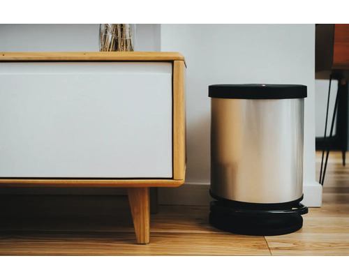 Elektrischer Abfalleimer aus Edelstahl neben einem Sideboard