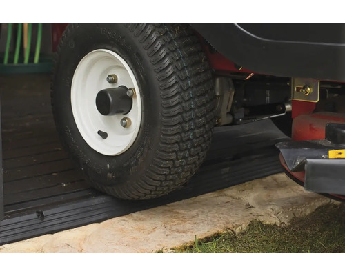 Detailaufnahme eines Rasentraktorreifens auf einem Schwellenprofil