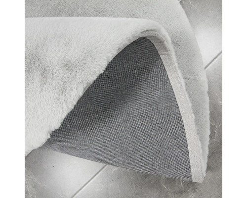 Detailansicht eines hellen Teppichs mit Flor und Textilrücken