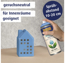 Dekorationsobjekt in Hausform wird mit Farbspraydose behandelt
