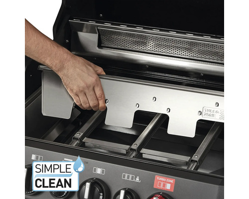 Ein Mann setzt eine Edelstahlplatte in einen Gasgrill ein.