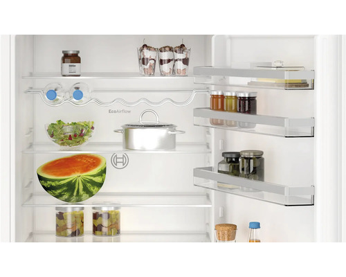 Innenansicht eines Kühlschranks mit verschiedenen Lebensmitteln auf den Regalen.