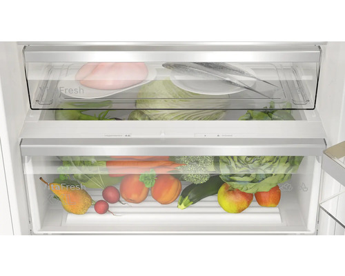 Innenraum eines Kühlschranks mit Gemüse und Lebensmitteln in transparenten Schubladen