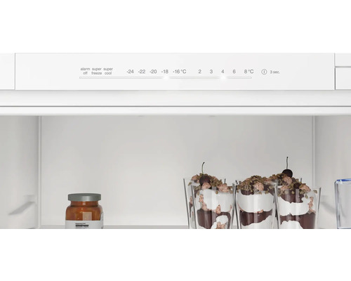 Innenraum eines Kühlschranks mit Temperaturregler und Lebensmitteln