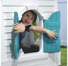 Junge schaut aus dem Fenster eines Spielhauses