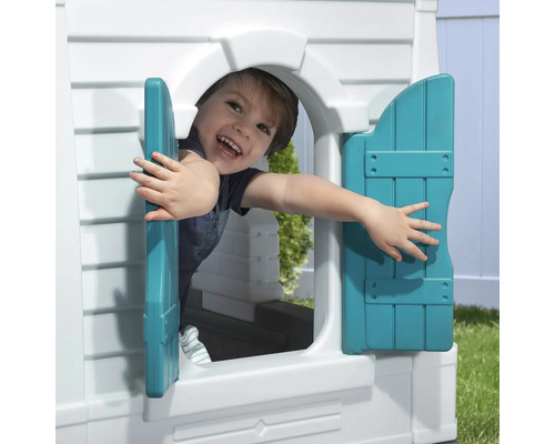 Junge schaut aus dem Fenster eines Spielhauses