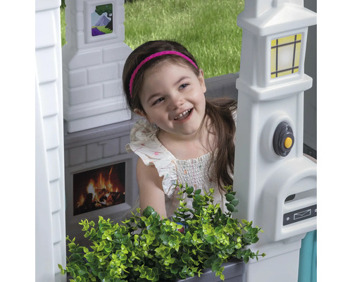 Mädchen im Spielhaus mit Briefkasten, Klingel, Kamin und Fensterbild