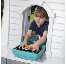 Junge spielt mit Burger im Spielhaus