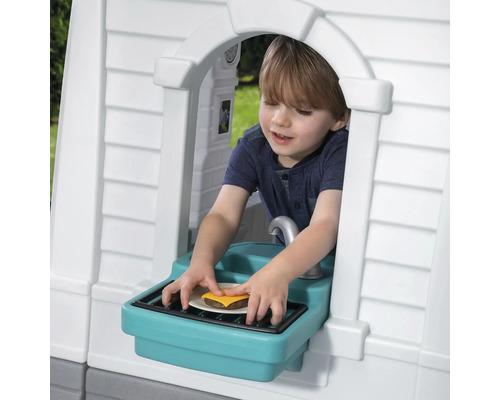 Junge spielt mit Burger im Spielhaus