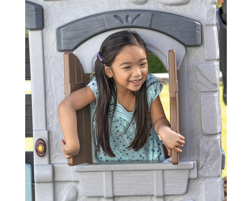 Mädchen spielt in einem Spielhaus mit Fenster