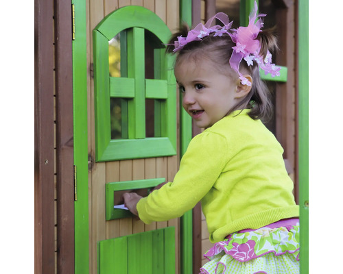 Ein junges Mädchen steckt einen Brief in den Briefkasten eines Spielhauses